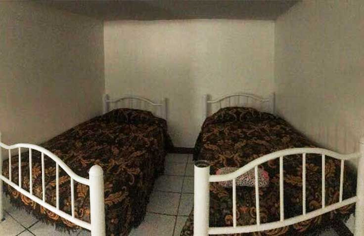 Hay dos camas una al lado de la otra en una habitación pequeña.