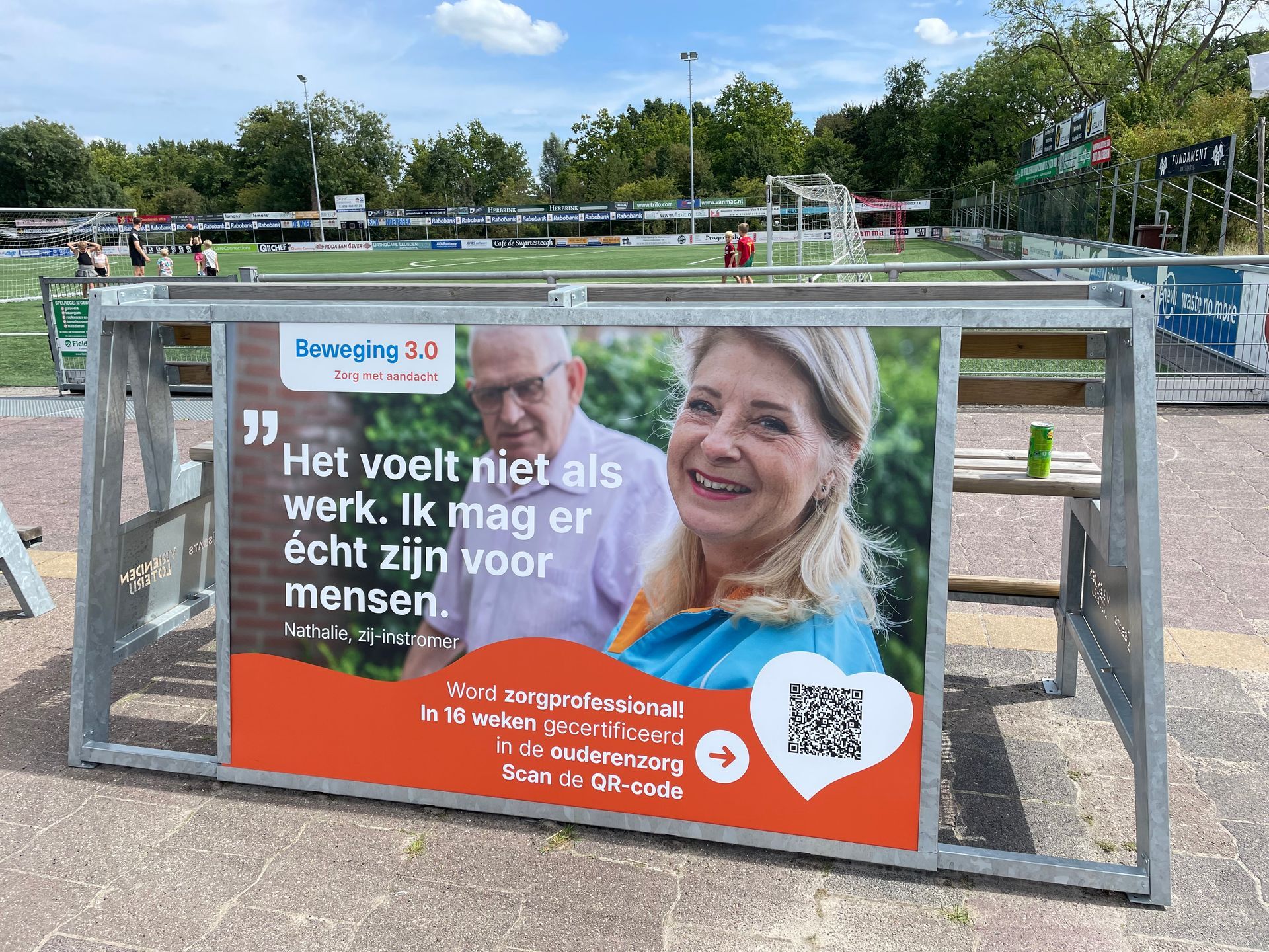 Bank voor sportclubs met tekst en foto's van twee personen, ter promotie van de gezondheidszorg.