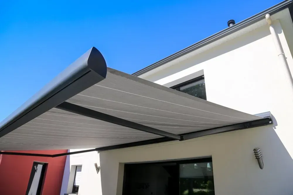 A White House With A Black Awning On The Side Of It — Coastal Blind Installations In Agnes Waters, QLD