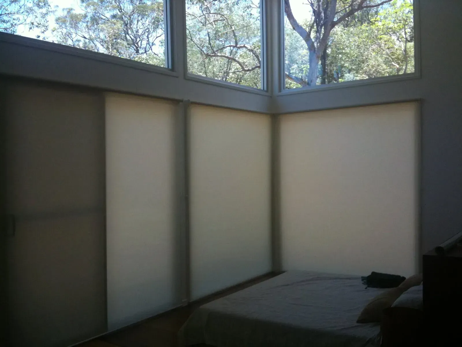 A Bedroom With A Bed And A Large Window — Coastal Blind Installations In Kensington, QLD