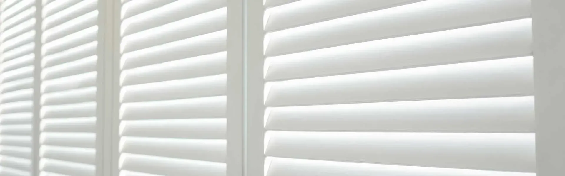 A Close Up Of A Row Of White Shutters On A Window — Coastal Blind Installations In Agnes Waters, QLD