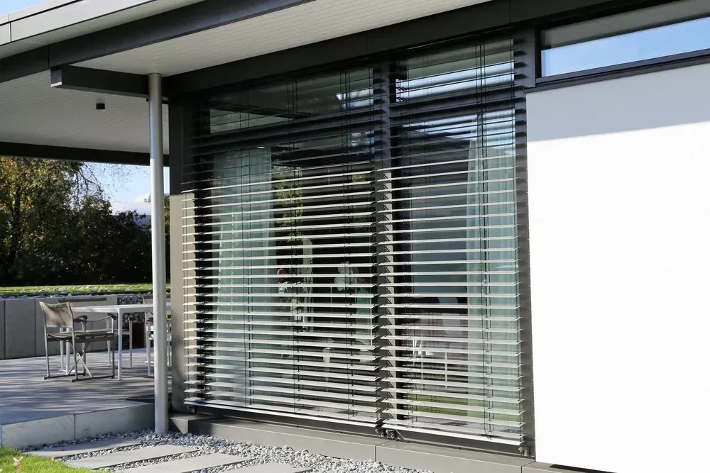 A House With A Sliding Glass Door With Blinds On It — Coastal Blind Installations In Bargara, QLD