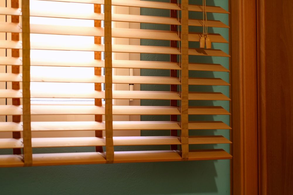 A Close Up of a Window With Wooden Blinds on It — Blinds Awning installation in Bundaberg QLD