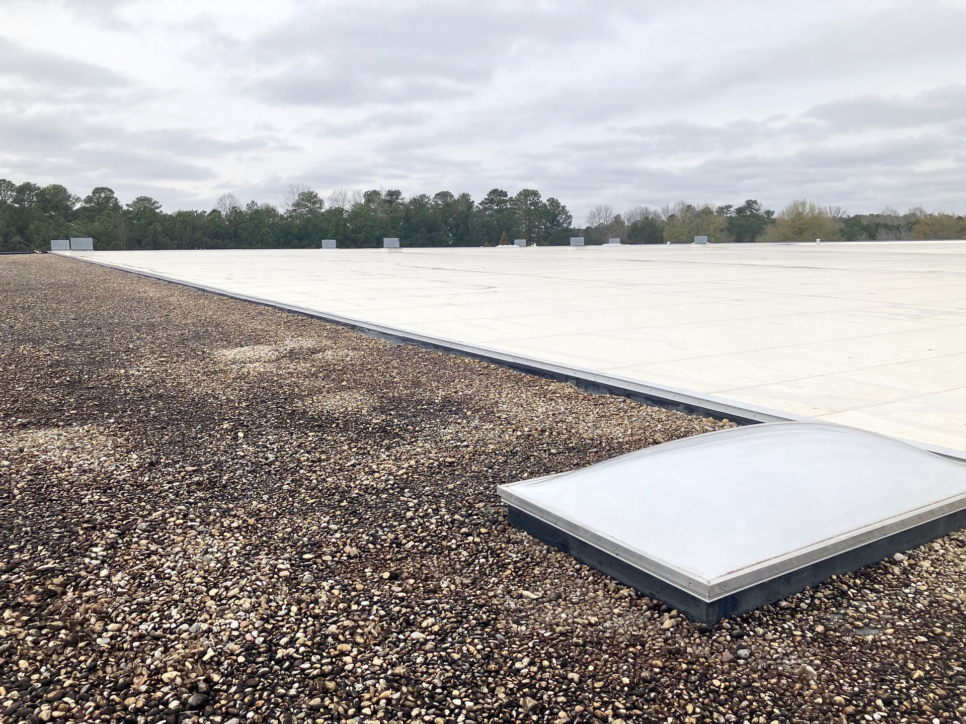 TPO roof on a commercial building with skylight and gravel edge