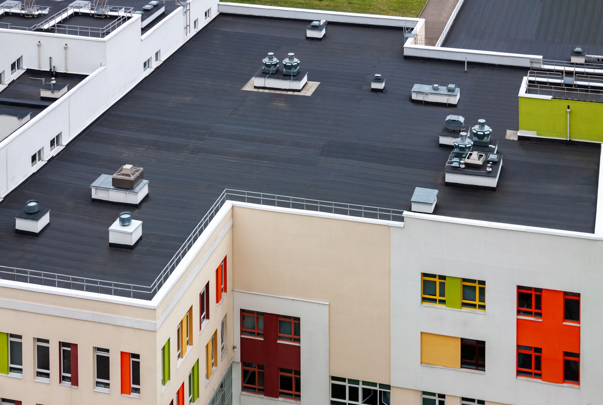 Aerial view of flat roof with HVAC units atop a modern building.