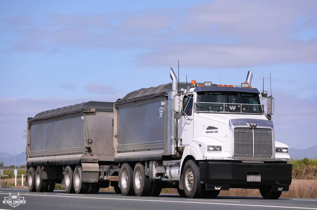 A White Semi Truck Is Driving Down A Road With A Trailer Attached To It — Petersen Tippers in Farleigh, QLD