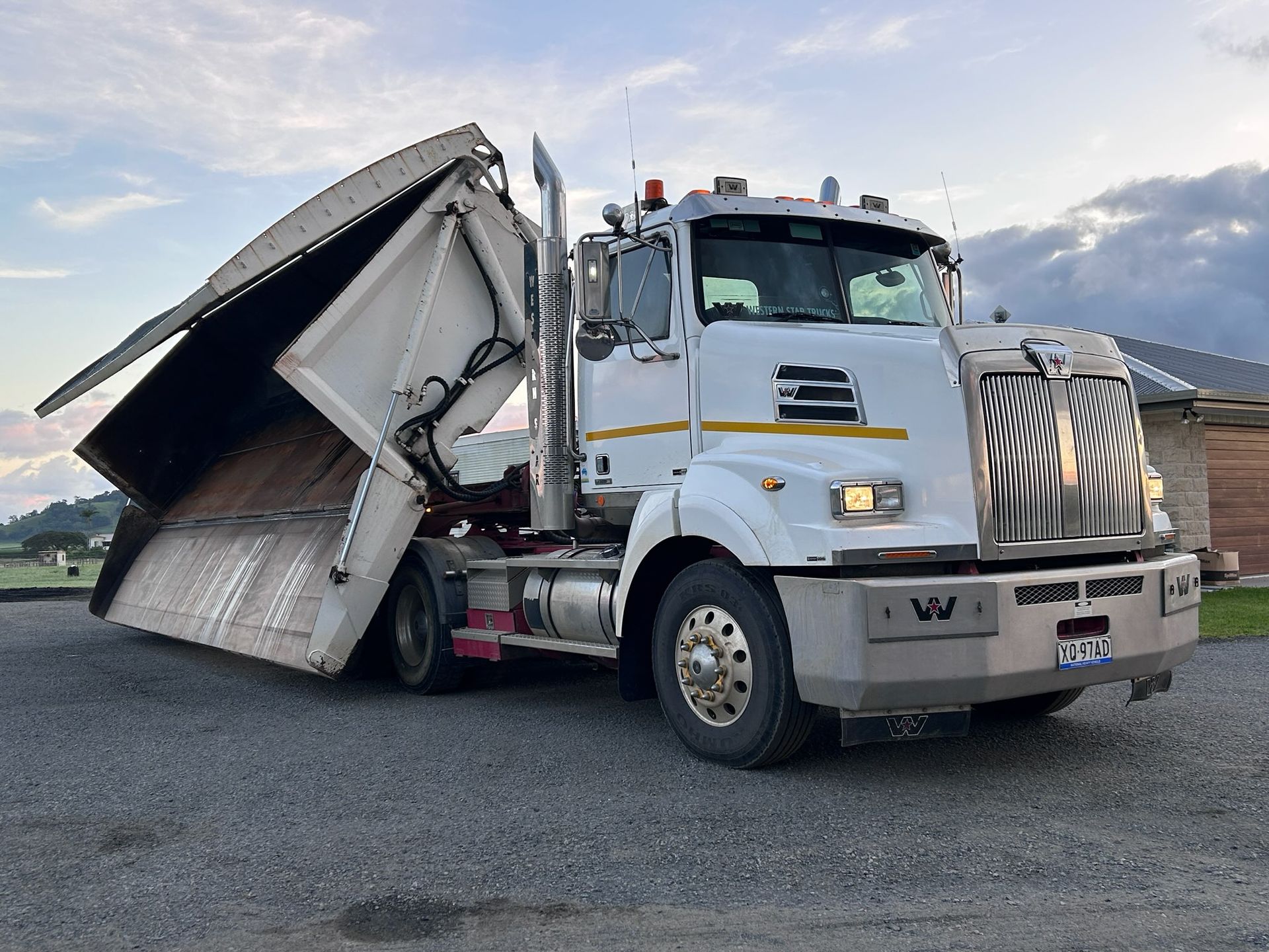 A White Dump Truck Is Parked In A Gravel Lot — Petersen Tippers in Farleigh, QLD