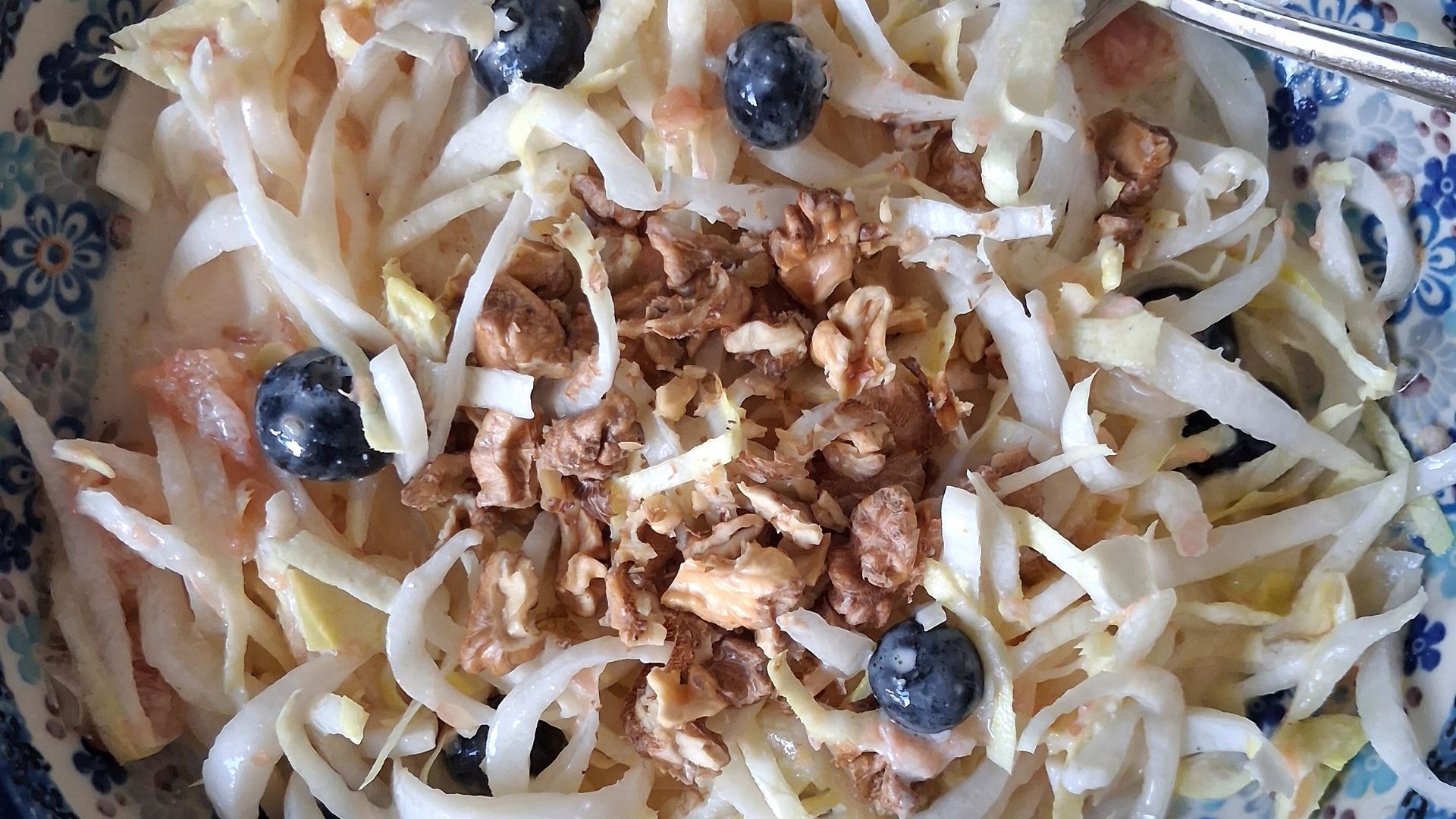 Frisse witlofsalade met grapefruitpartjes, blauwe bessen, walnoten en yoghurtdressing in een witte s
