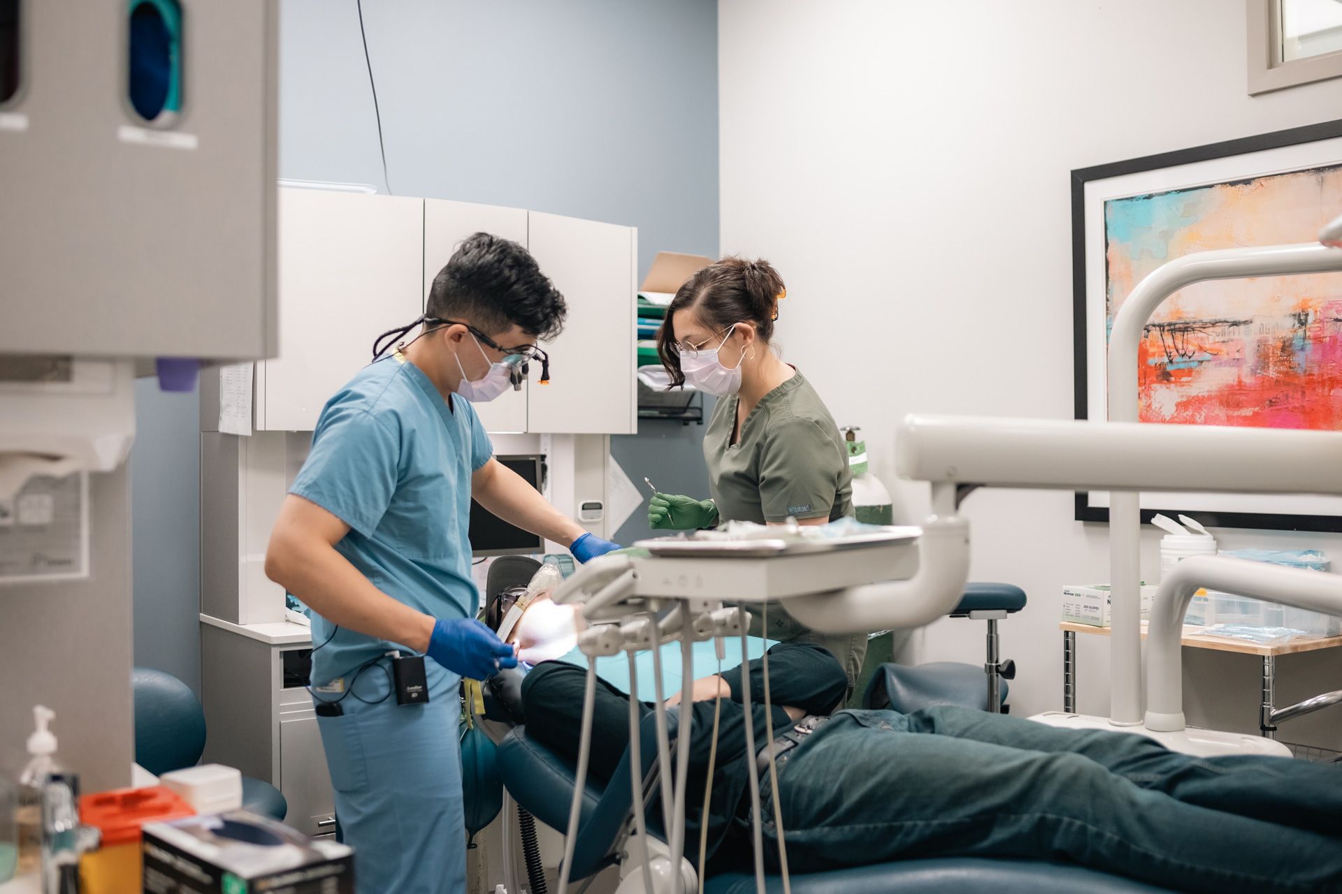A dentist is examining a patient 's teeth in a dental office.