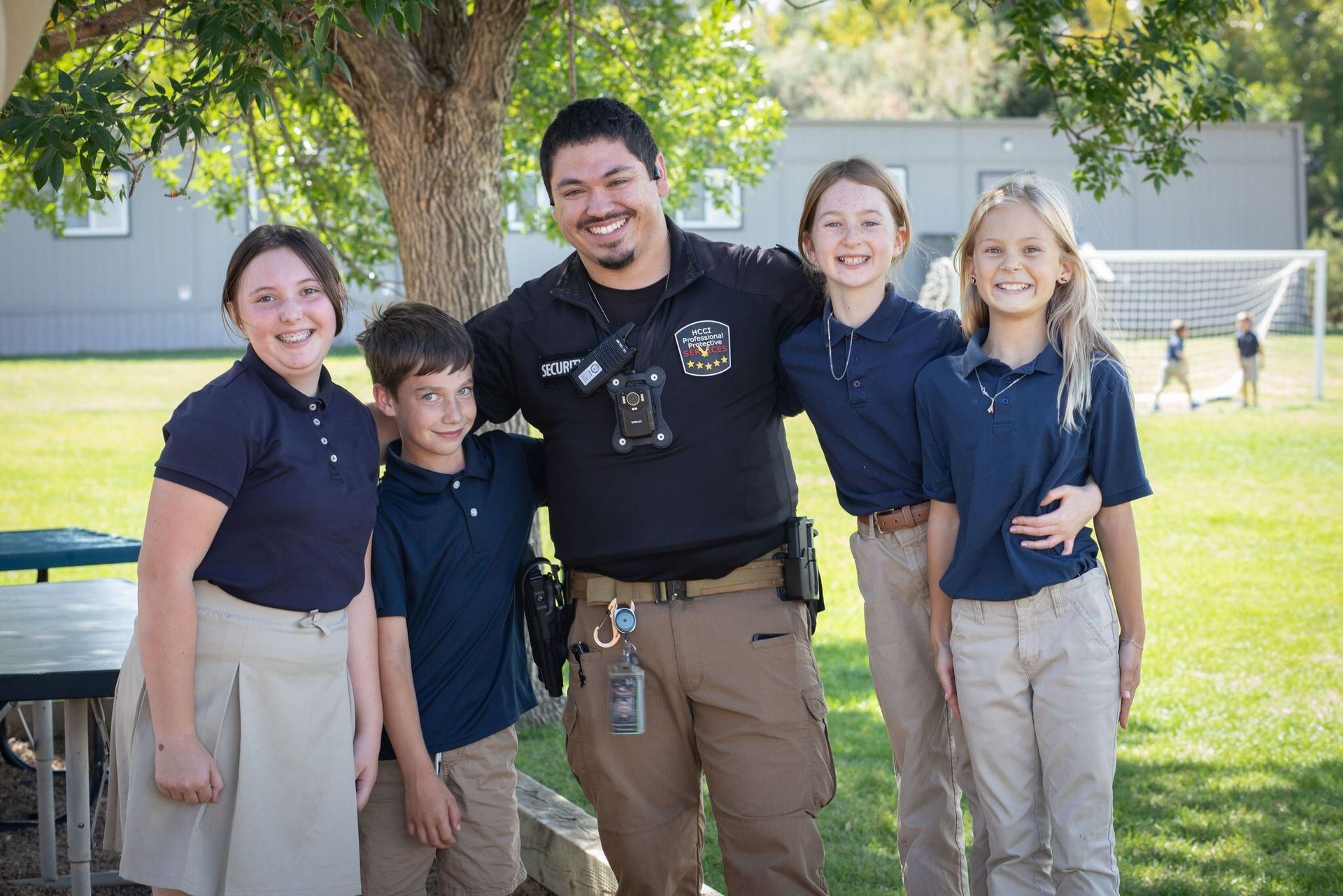 A group of children are posing for a picture with a police officer.