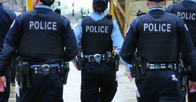 A group of police officers are walking down a street.