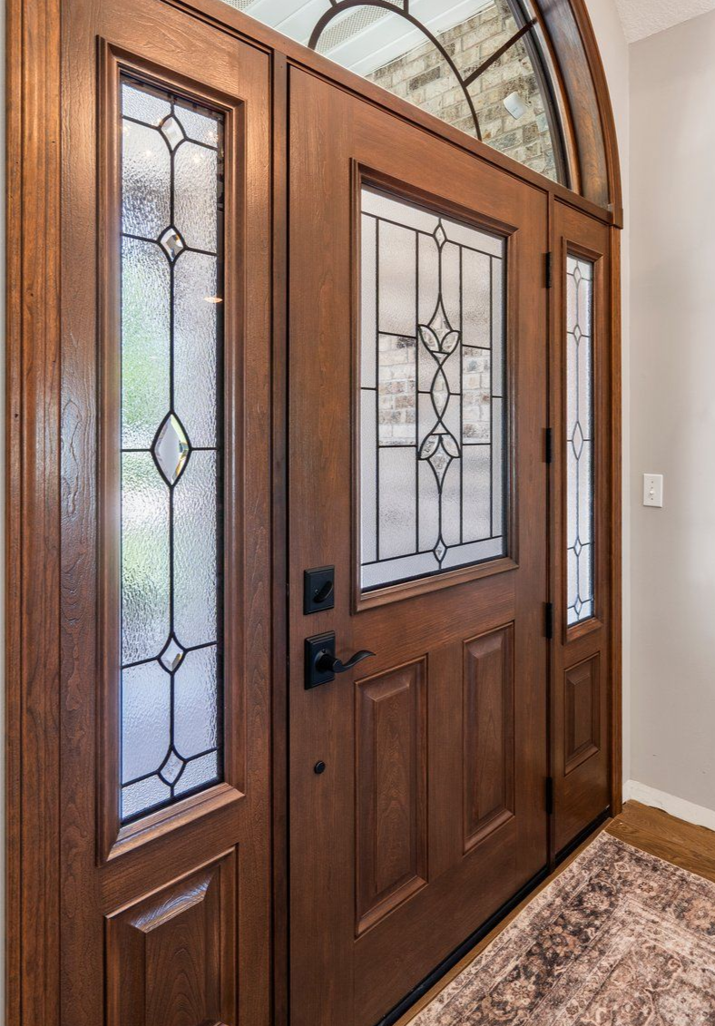 Brown wooden front door with stained glass panels.