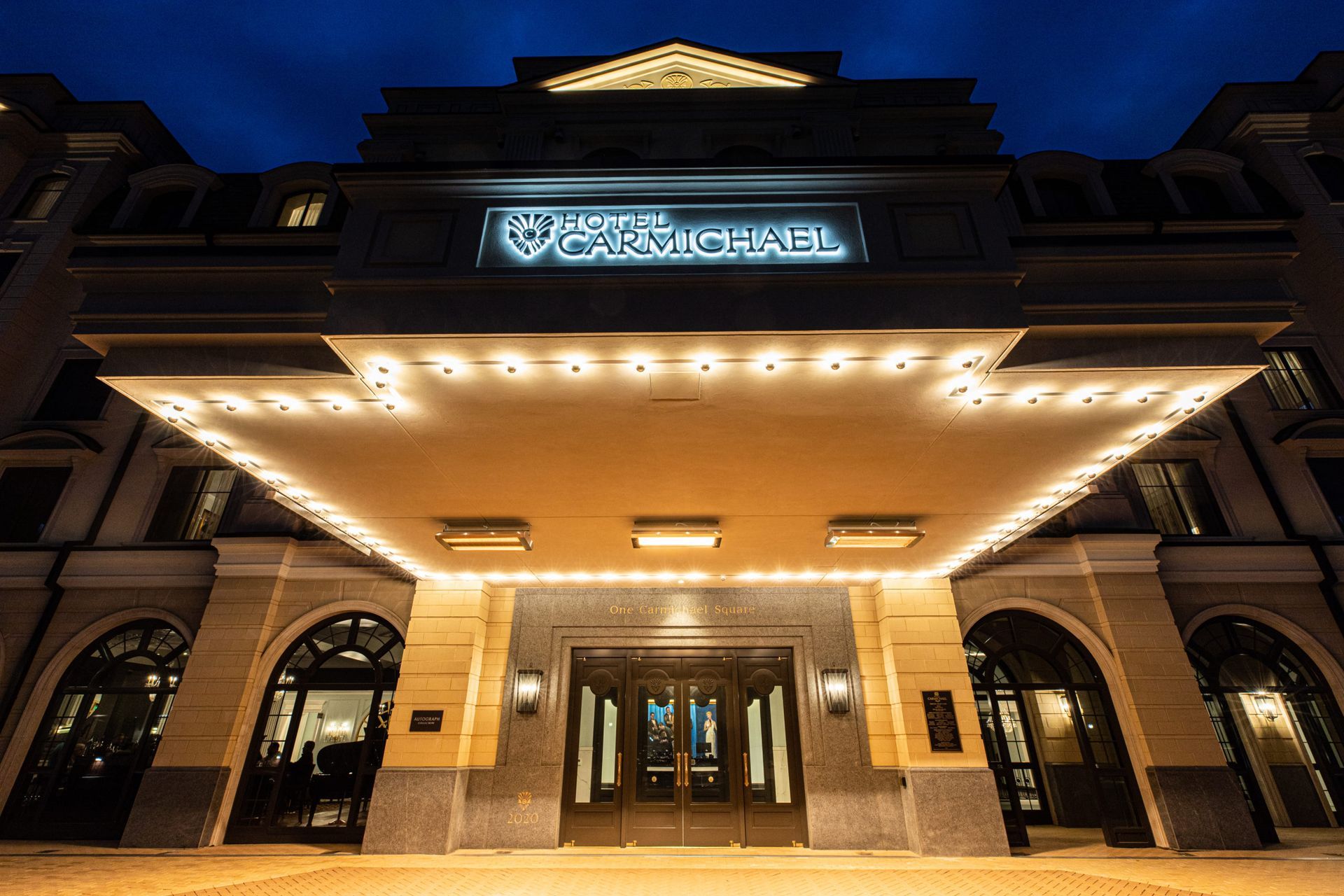 A large building with a canopy over the entrance at night.