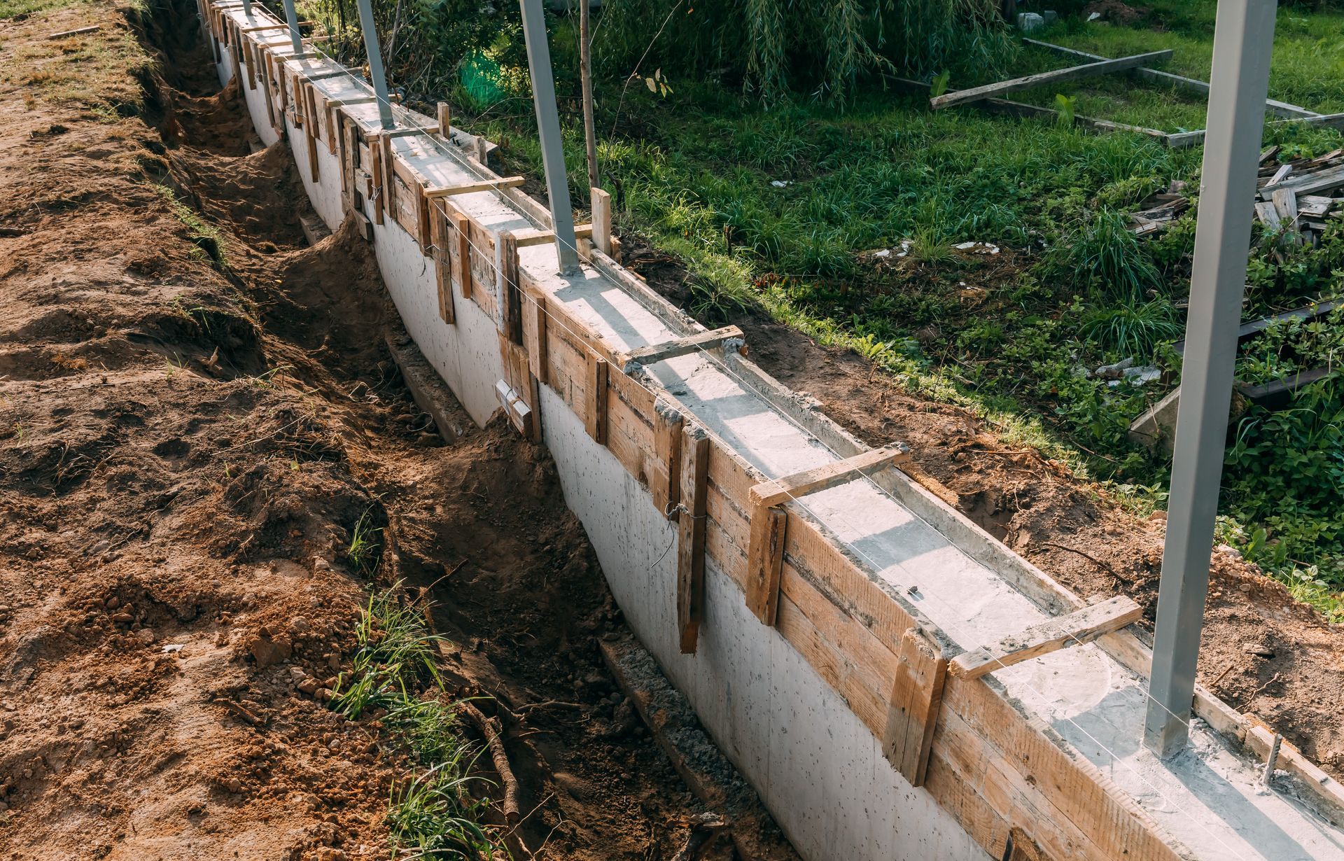 Timber formwork with metal retaining walls post-reinforced with pour concrete