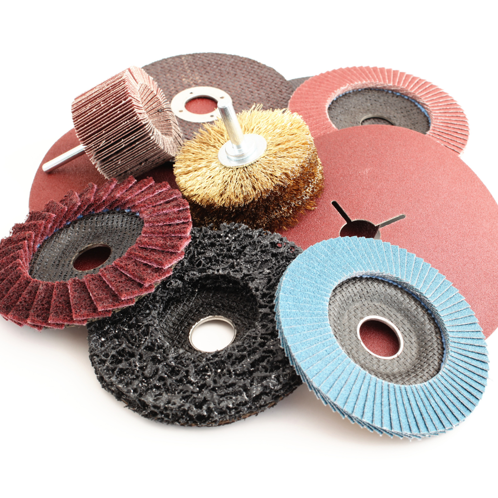 Assorted abrasive sanding and grinding discs and wheel brushes in red, blue, black, and gold.