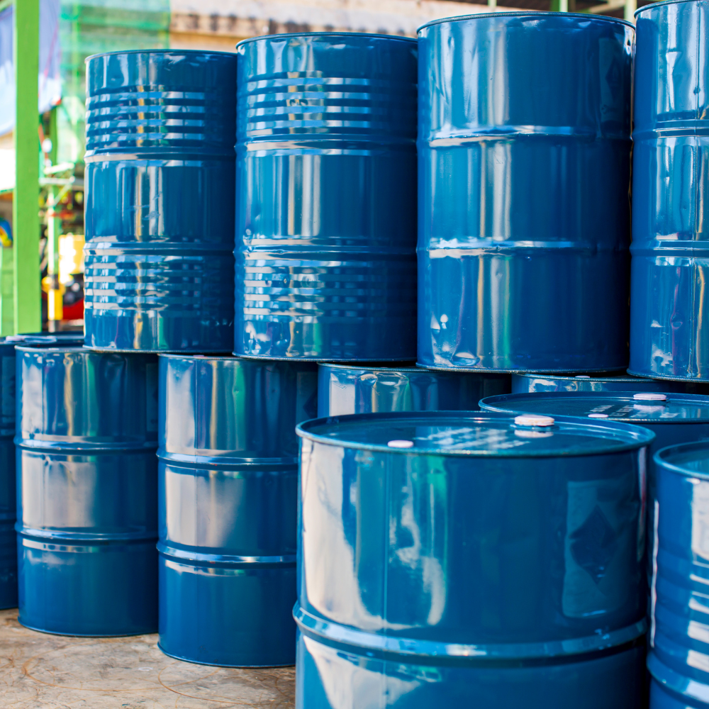 Stacks of blue metal barrels in an industrial storage area