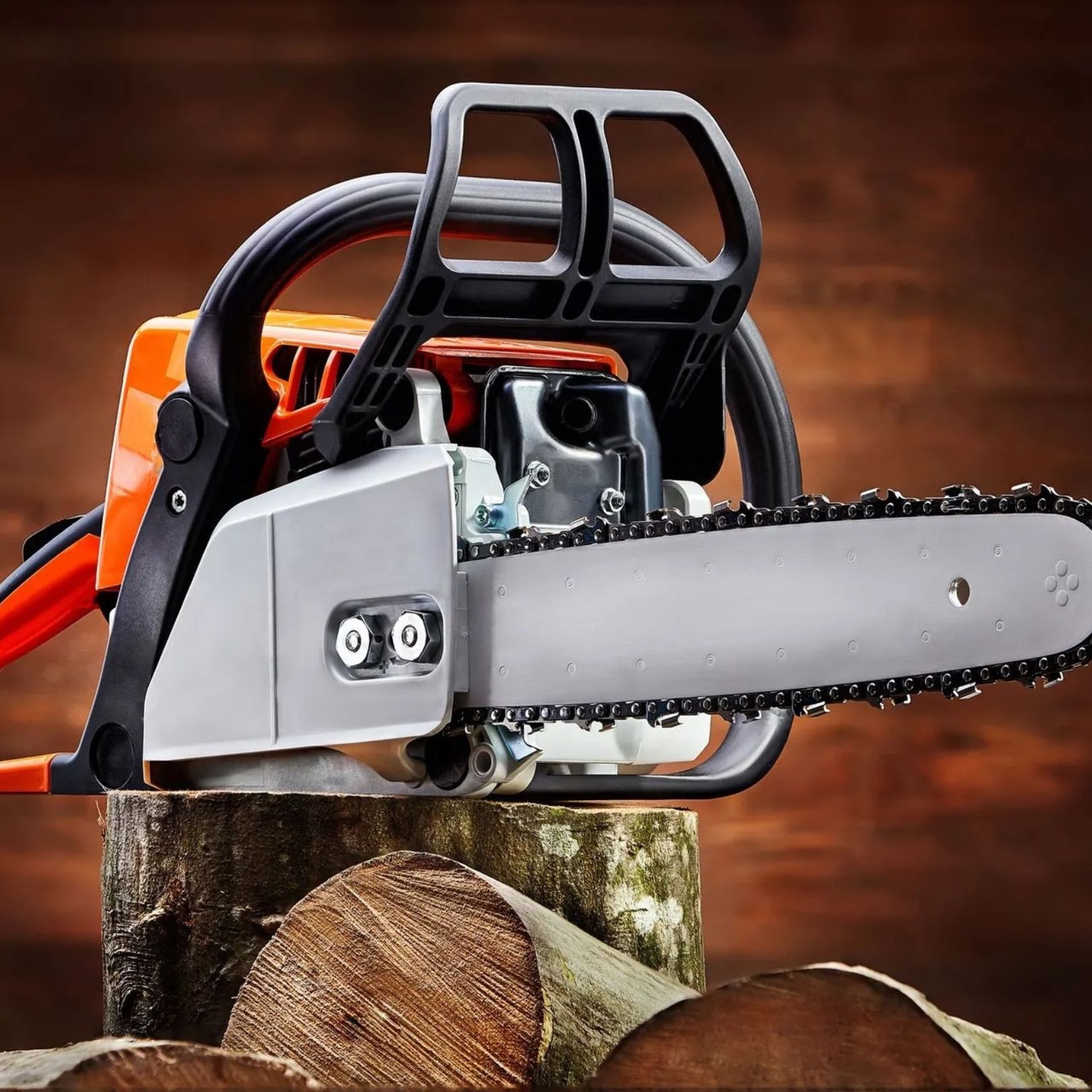 Chainsaw cutting a log, with silver blade and black-orange body in a wooded setting