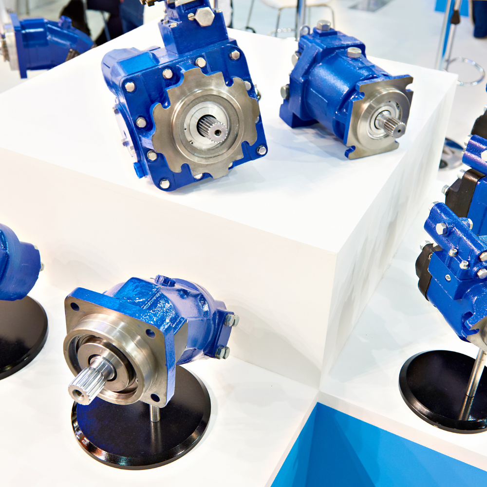 Blue industrial gearboxes displayed on white stands in a showroom