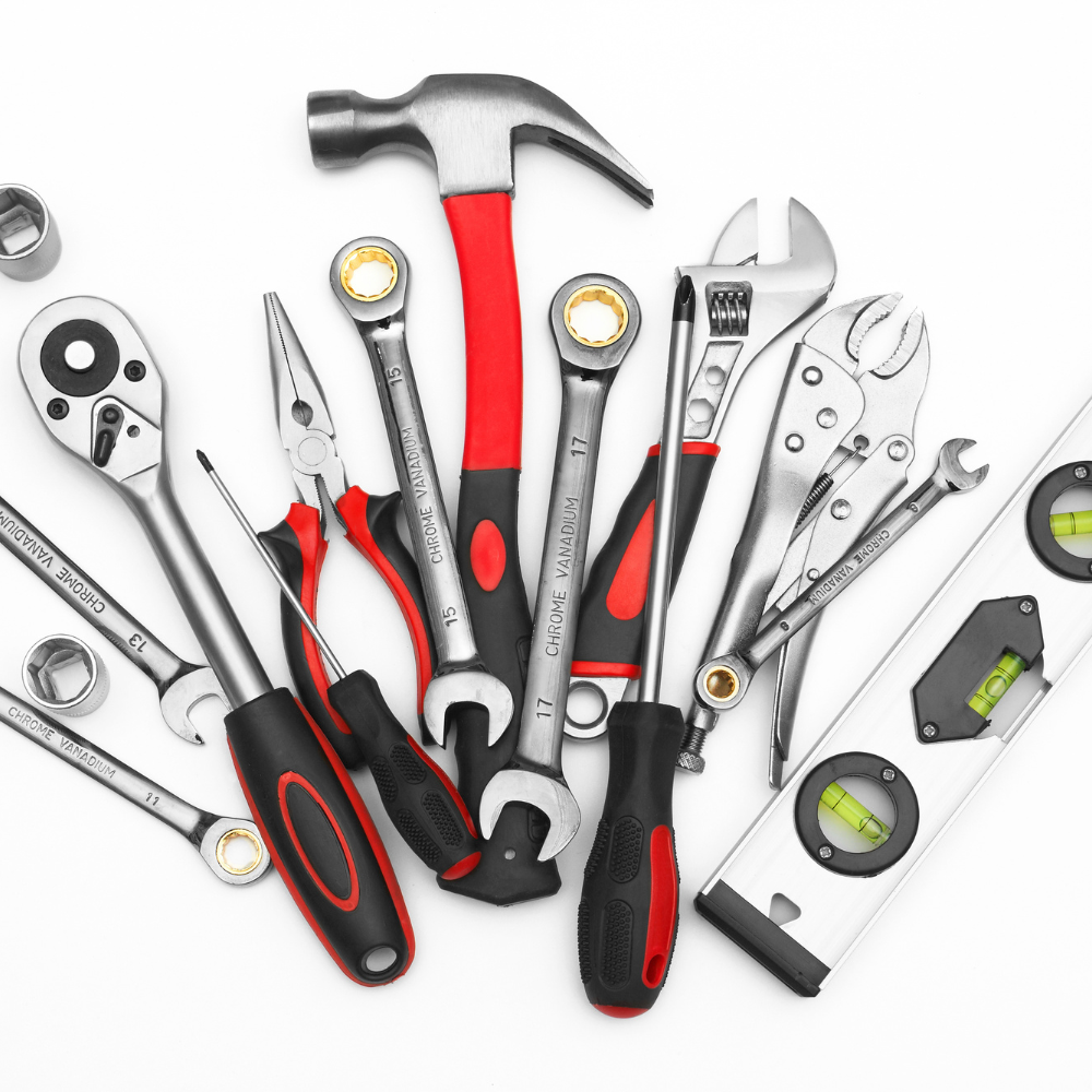 Assorted hand tools on a white background, including wrenches, pliers, screwdrivers, hammer, and level.