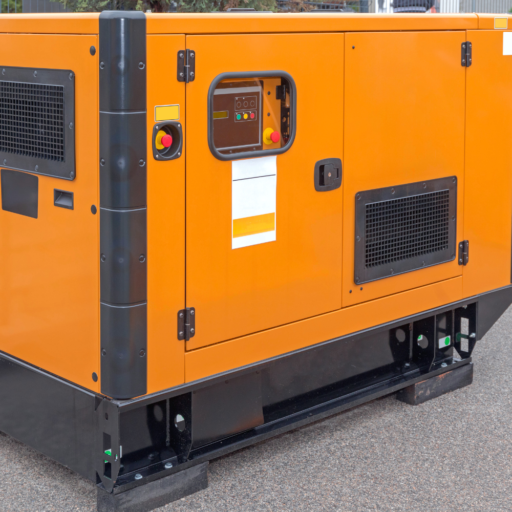 Orange industrial generator with vents, control panel, and black base on pavement