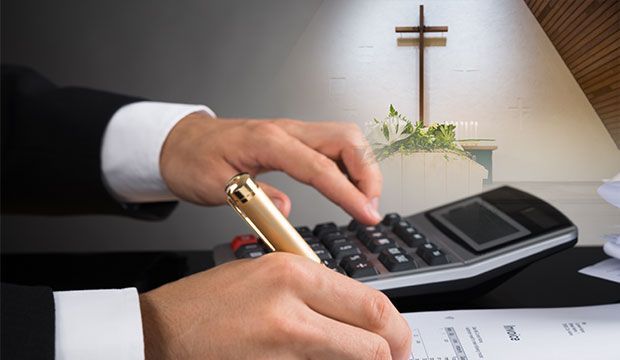 Un hombre está usando una calculadora y escribiendo en un trozo de papel.