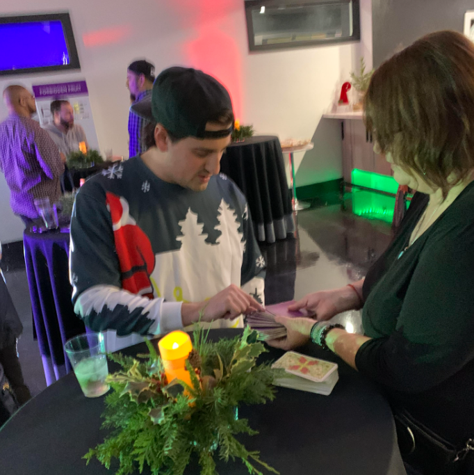 Tarot Card Reader, Lisa O'Neil, gives reading to guest  at Dime Industries holiday party in Irvine, Ca.