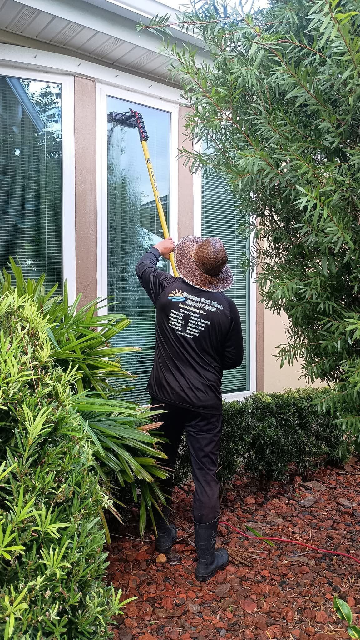 Worker on ladder cleaning the front entrance of Hardage-Giddens Greenlawn Funeral Home & Cemetery