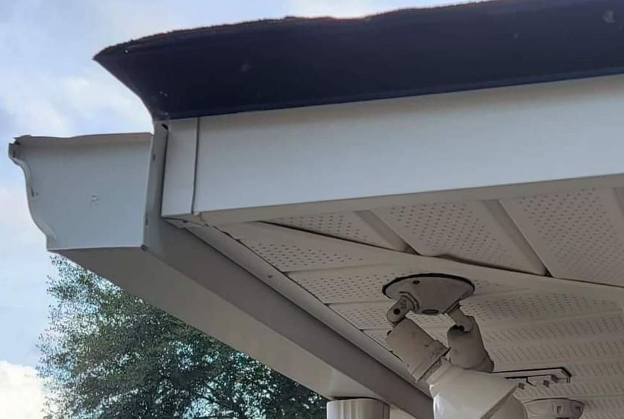 White house eave with gutter and hanging black lantern above a residential street