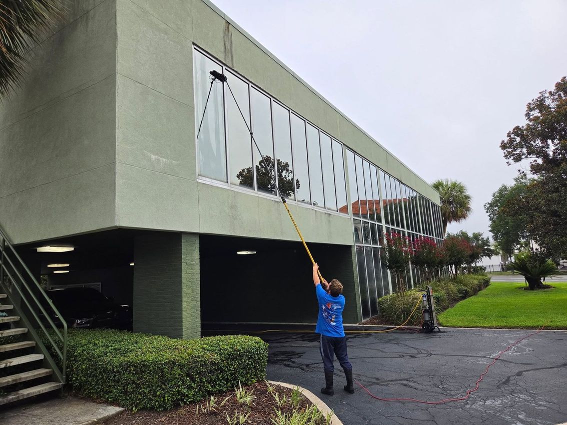 Person on ladder painting the sign at Hardage-Giddens Greenlawn Funeral Home & Cemetery entrance
