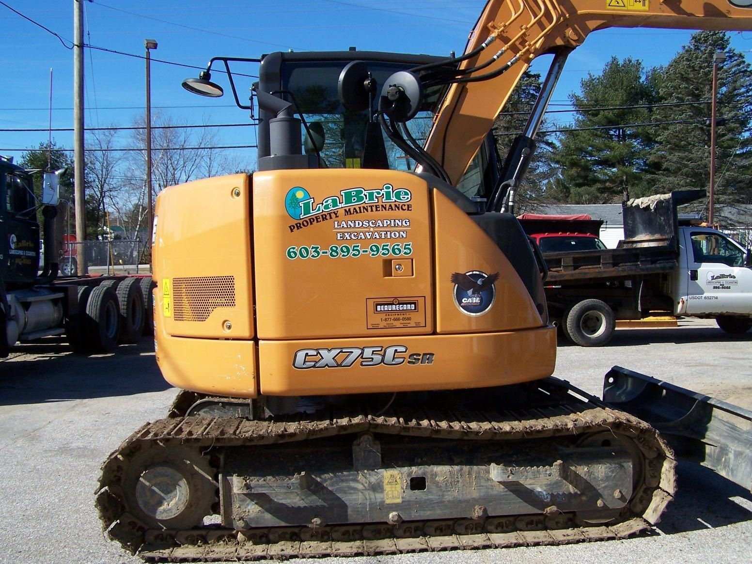 A case excavator is parked in a parking lot
