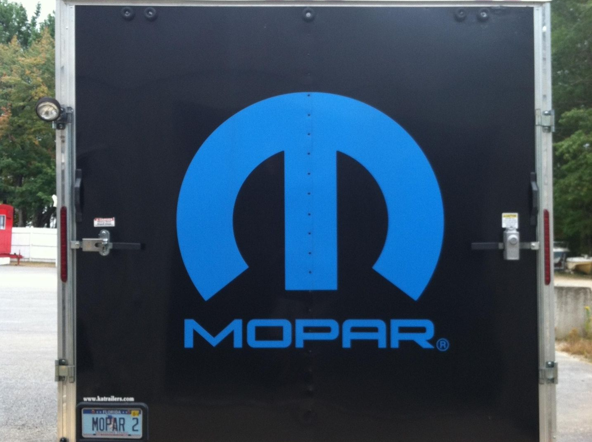 A black trailer with a blue mopar logo on it