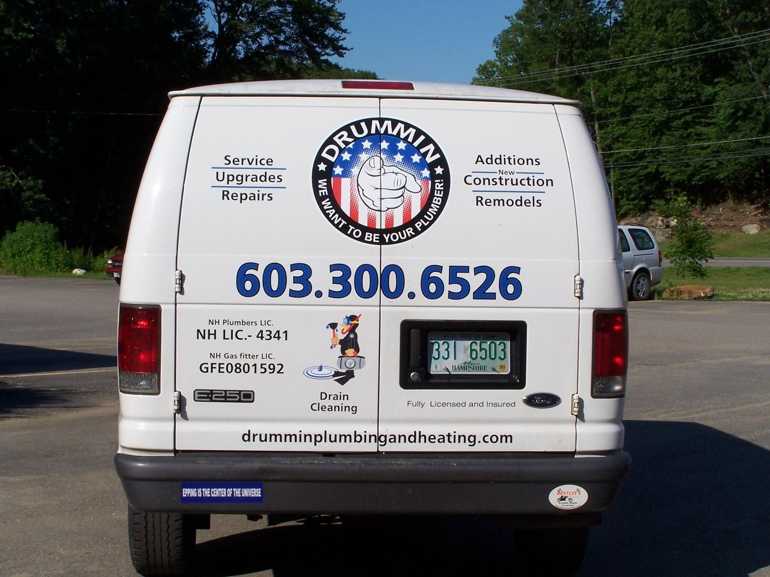 The back of a white van that says drummin plumbing on it