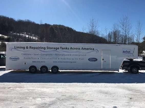 A white trailer is parked in the snow and says lining and repairing storage tanks across america