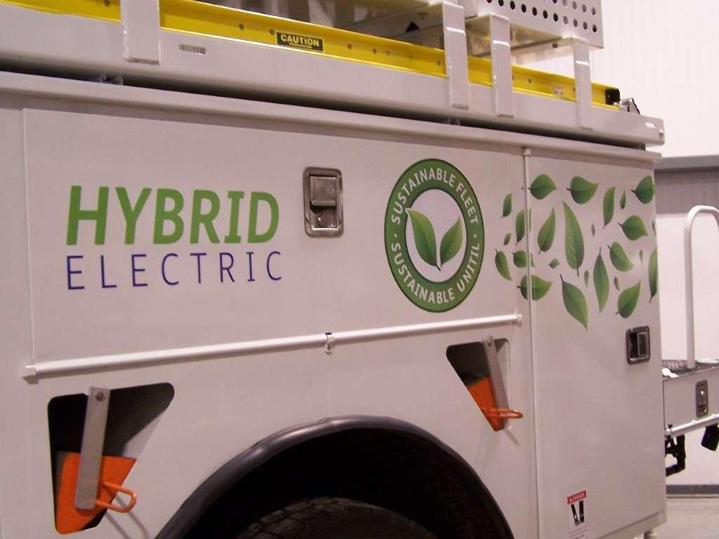 A hybrid electric truck is parked in a garage