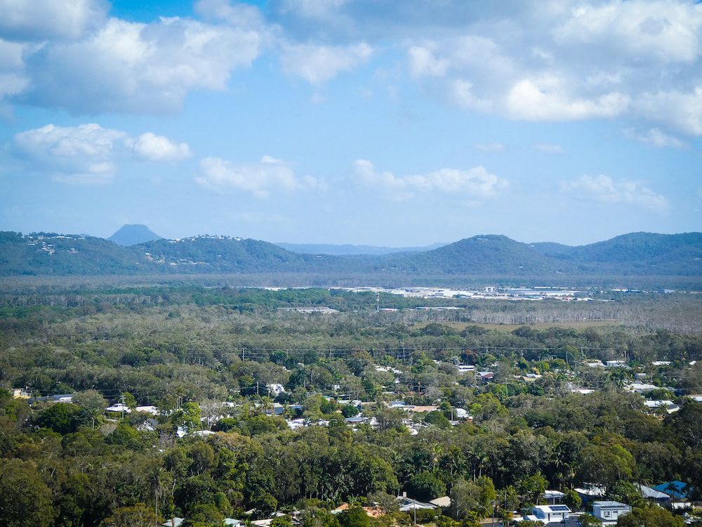 An Aerial View of a City Surrounded by Trees and Mountains — Coolum Cutting Edge in Doonan, QLD