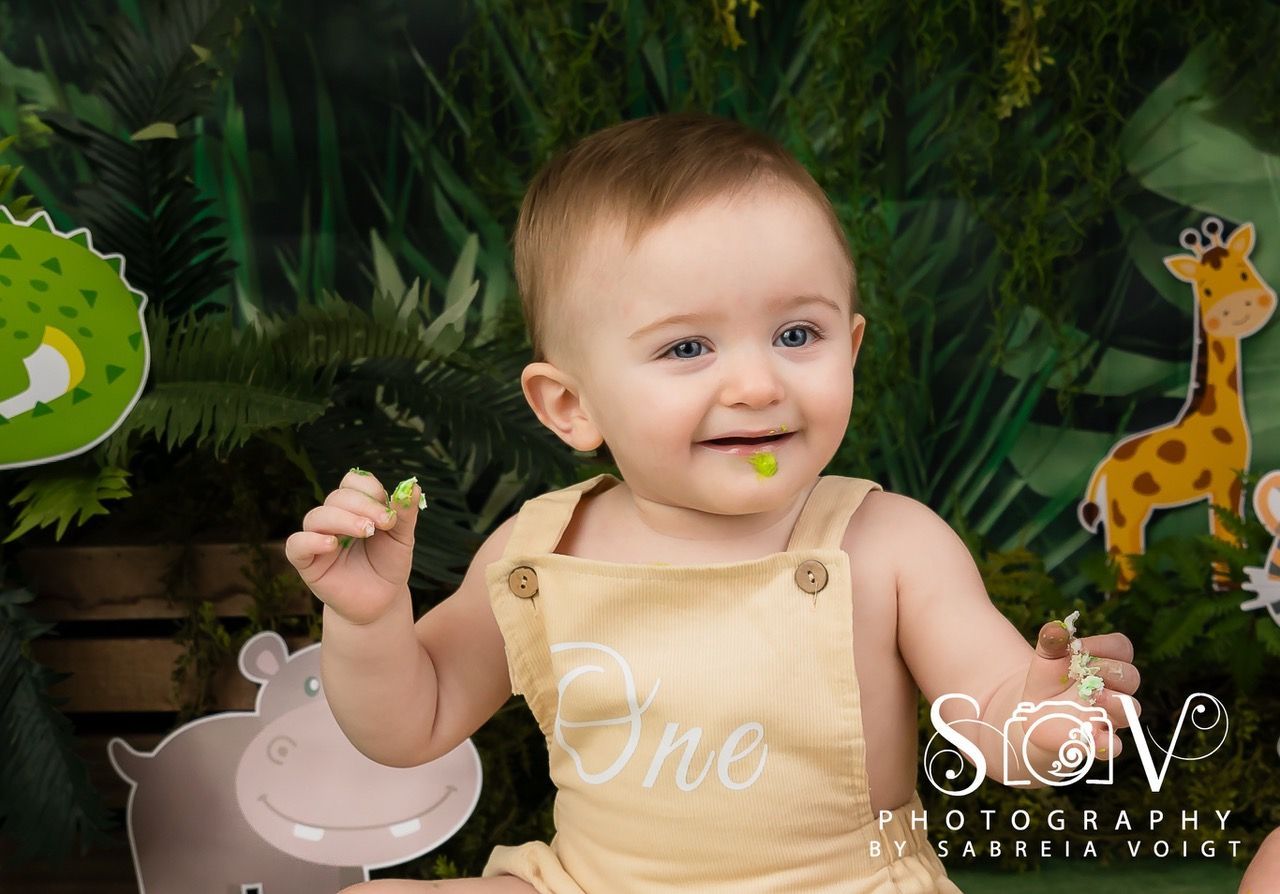 Smiling baby in tan overalls with a 