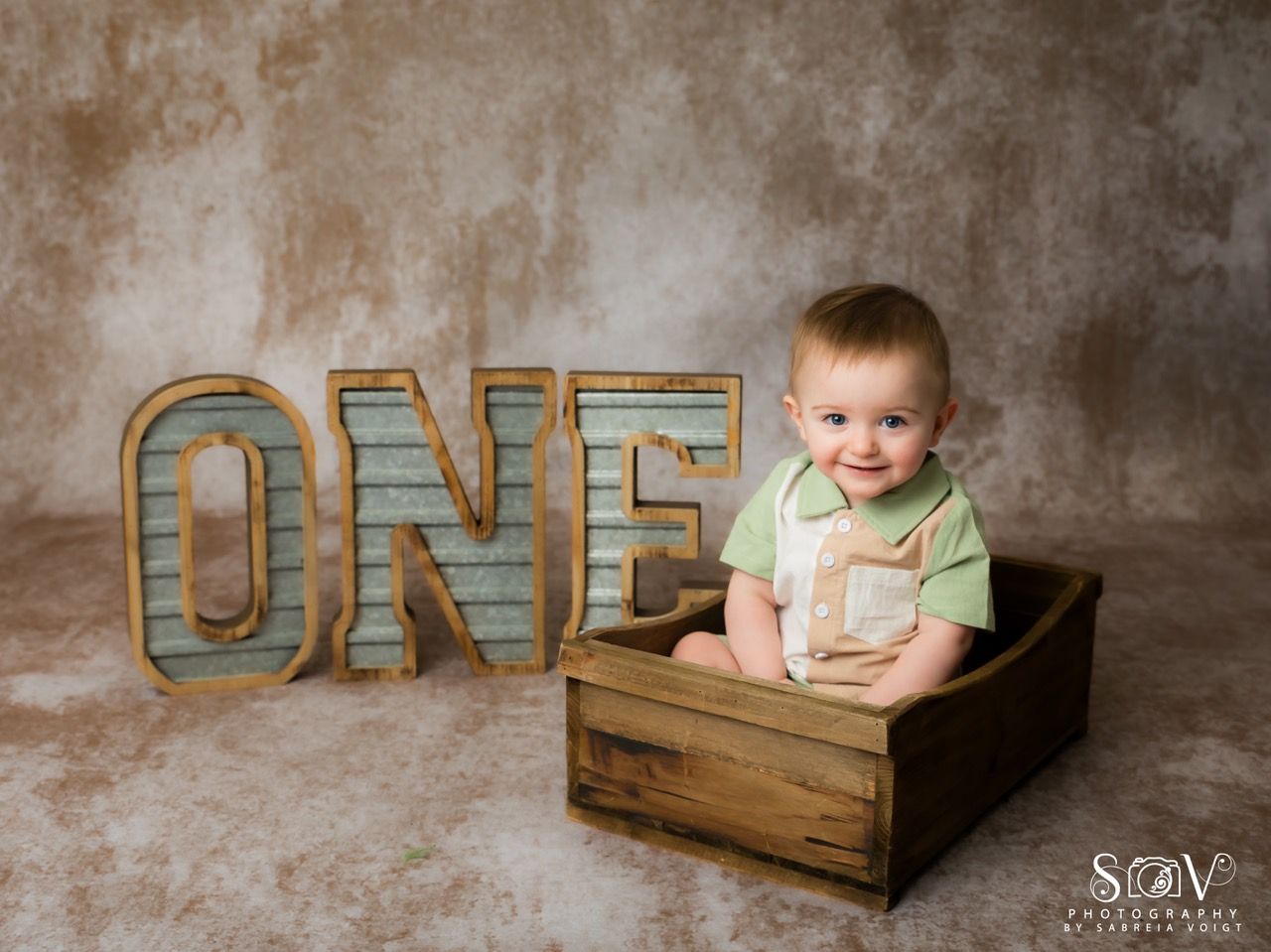 Smiling baby in a wooden box with 