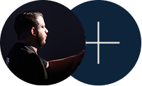 Silhouetted man in profile beside a dark blue circle with a white plus sign