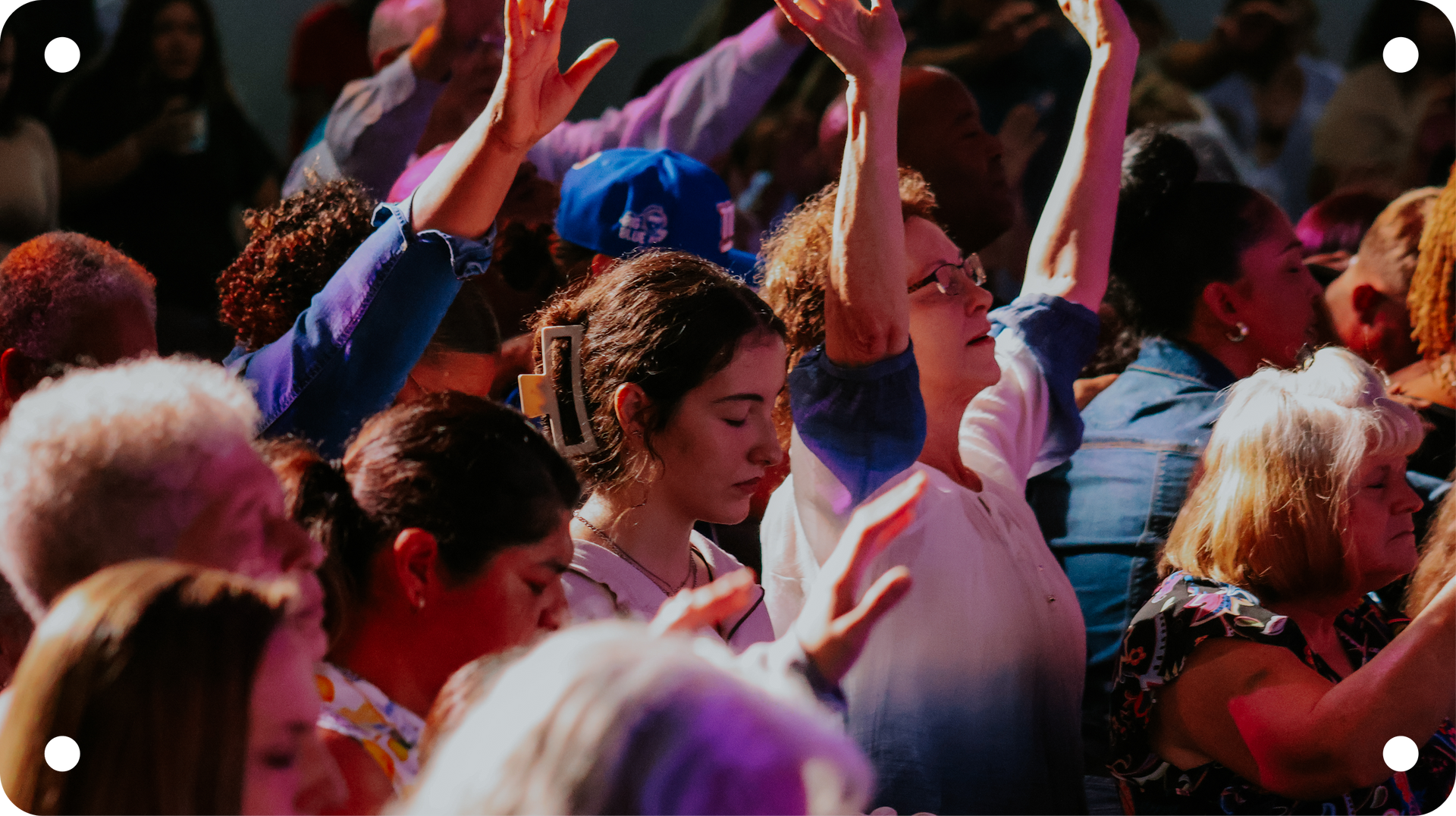 Crowd dancing with raised hands at a colorful outdoor festival