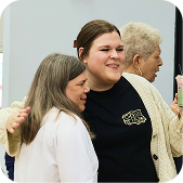 Three people smiling and embracing at a social gathering
