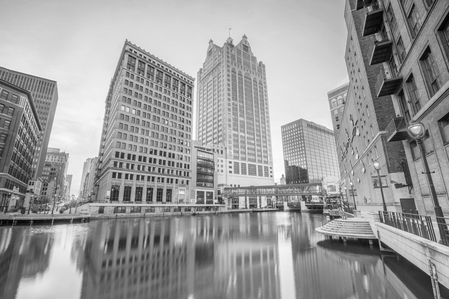 A black and white photo of a city with buildings and a body of water.