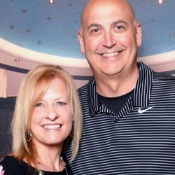 A man and a woman are posing for a picture together and smiling.