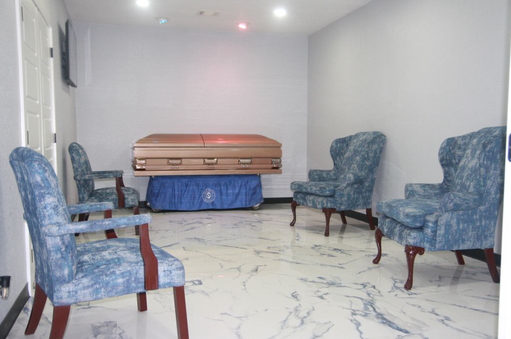 A room with chairs and a coffin in it