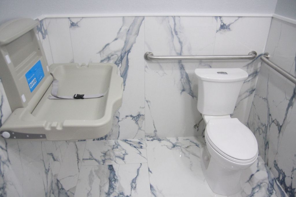 A bathroom with a toilet and a changing table.