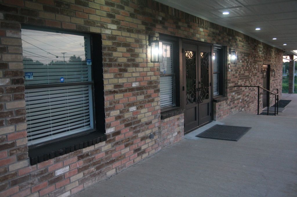 A brick building with a porch and a door.