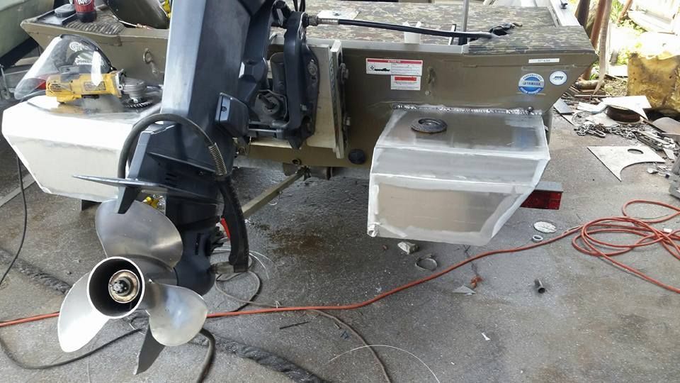 A boat motor and propeller attached to the stern of a boat with a fuel tank.