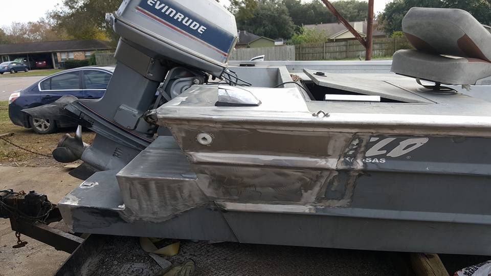 Gray aluminum boat with Evinrude motor on a trailer.