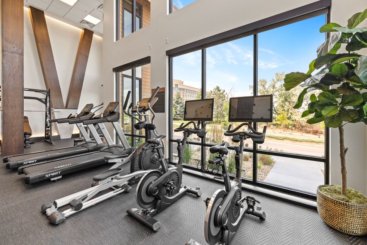 The Lock at Flatirons Well-lit fitness center with treadmills, stationary bikes, and large windows.