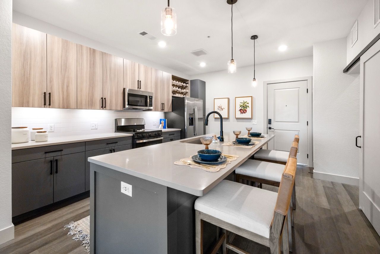 The Lock at Flatirons Modern kitchen with an island, pendant lights, and stainless-steel appliances.