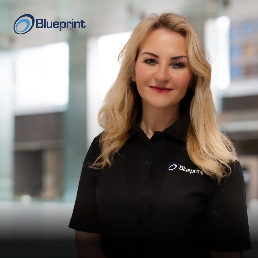 A woman wearing a black shirt with the word blueprint on it